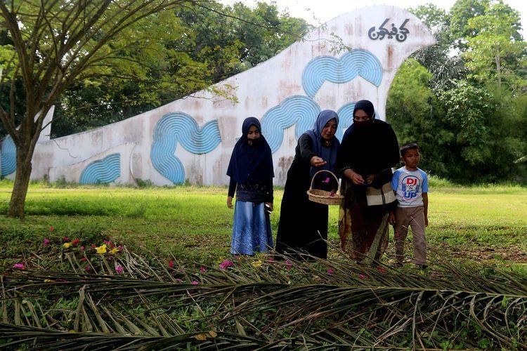 Peziarah-mendoakan-keluarga-mereka-yang-menjadi-korban-gempa-dan-tsunami.jpg