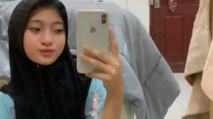 TINGGALKAN RUMAH - Anisa Azkia (16), melihat hp saat di rumah di Gampong Paloh, Kecamatan Pidie, Kabupaten Pidie. Siswi kelas dua SMA Negeri 1 Sigli ini dilaporkan meninggalkan rumah sejak Sabtu (8/11/2025) usai pulang sekolah.