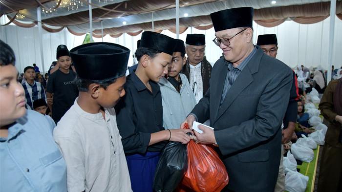 Bupati Tagore Abubakar, menyerahkan bingkisan kepada anak yatim dalam