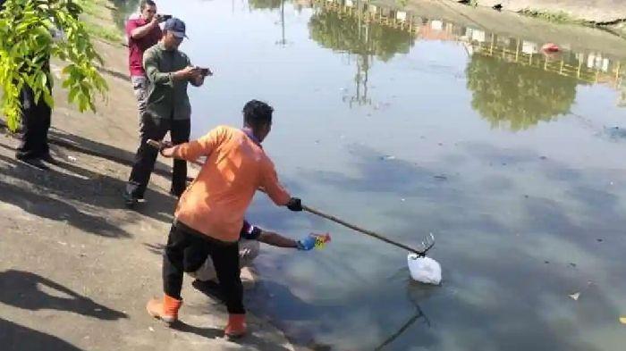 EVAKUASI JASAD BAYI - Seorang warga mengevakuasi jasad bayi yang terbungkus dalam plastik dari dalam sungai di Gampong Punge Jurong, Kecamatan Meuraxa, Kamis (30/4/2026). (Serambinews.com/HO)