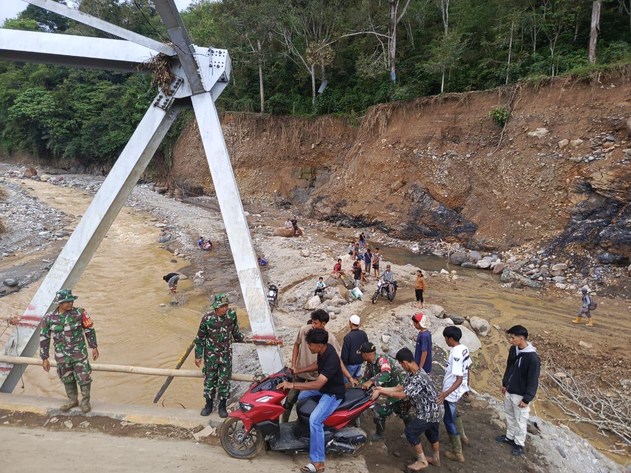 Seorang warga menyeberangi jembatan dengan memanfaatkan tali gantung beralas drum sebagai sarana transportasi darurat. Akibat imbas putusnya Jembatan Pelang yang menghubungkan Kecamatan Silih Nara dan Rusip Antara, Aceh Tengah, Sabtu (6/12/2025).