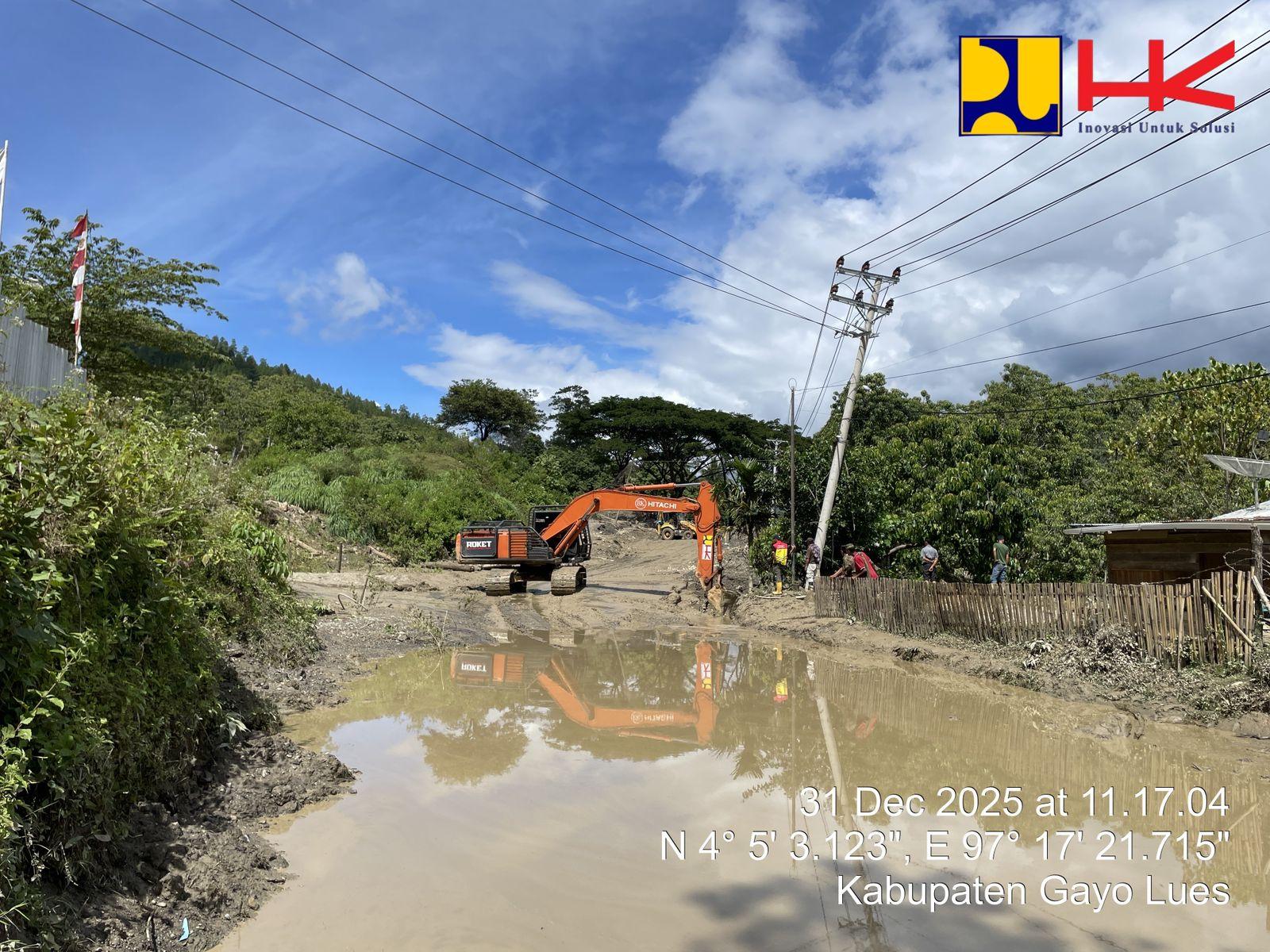 Excavator sedang membersihkan material sisa longsor di ruas jalan Gayo Lues - Aceh Tenggara, kawasan Putri Betung, Gayo Lues, Rabu (31/12/2025).