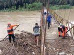 BPBD-Aceh-Tamiang-membersihkan-tumpukan-kayu-yang-hanyut-terbawa-banjir.jpg
