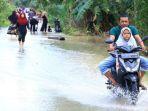 Pengendara-sepeda-motor-mencoba-melintasi-jalan-yang-tergenang-banjir-di-Aceh-Tamiang.jpg