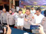 Polisi-tengah-memperlihatkan-seorang-preman-yang-telah-melakukan-pemerasan-dan-pengancaman.jpg