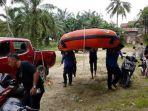 Regu-penolong-menggotong-perahu-karet-yang-akan-digunkan-menyisir-sungai-Tamiang.jpg