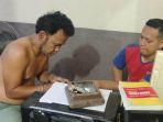 Tersangka-BT-kiri-saat-menjalani-pemeriksaan-di-Polsek-Kualasimpang.jpg