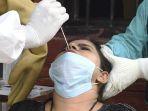 petugas-kesehatan-melakukan-swab-terhadap-seorang-wanita-india.jpg