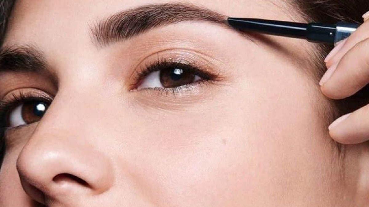 Ilustrasi wanita mengguanka eyebrow pencil dengan formula waterproof.