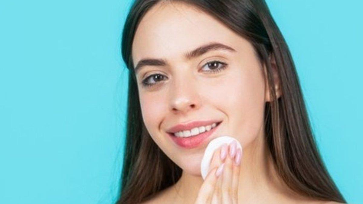 Ilustrasi wanita menggunakan micellar water untuk membersihkan makeup waterproof.