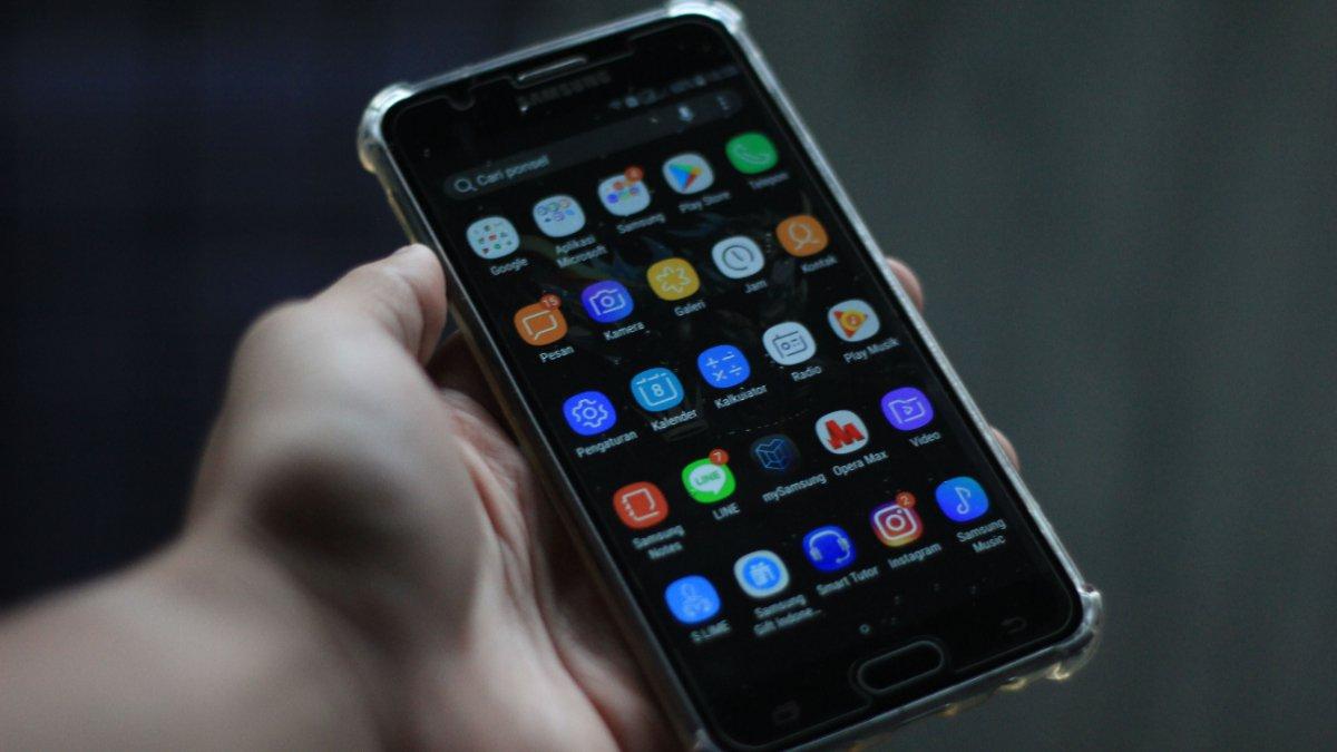 Close-up smartphone yang menampilkan berbagai aplikasi mobile di layarnya.