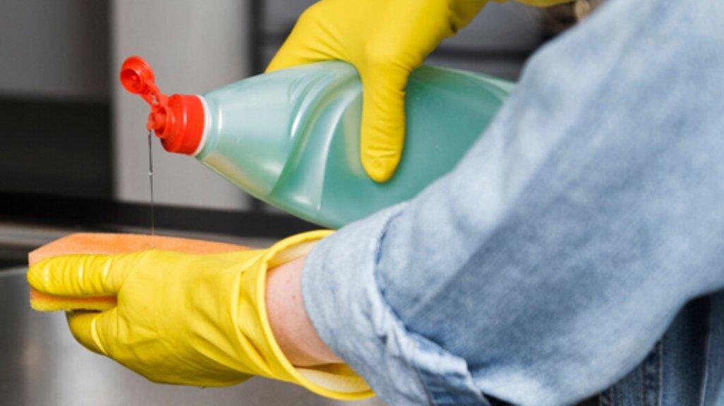 Ilustrasi mencuci piring dengan sarung tangan.