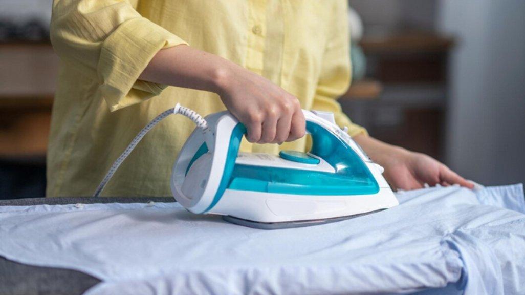 Ilustrasi menyetrika pakaian.