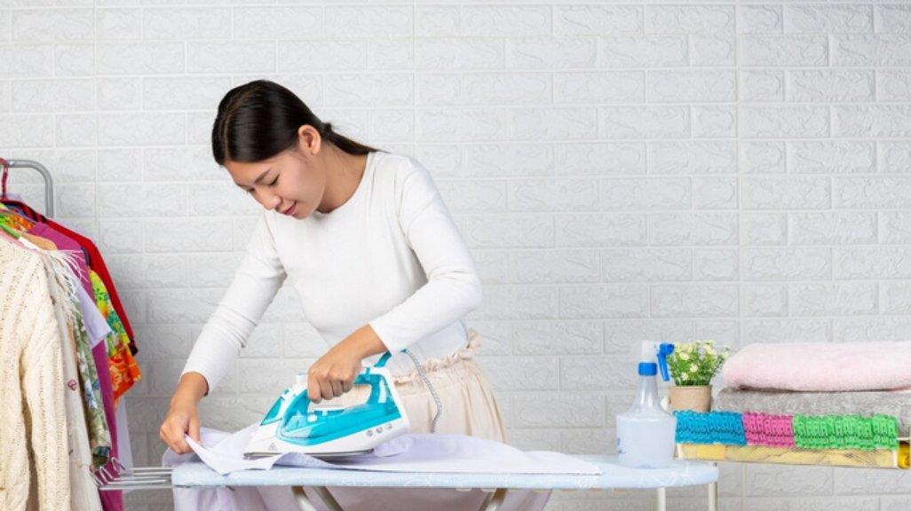 Ilustrasi menyetrika pakaian.