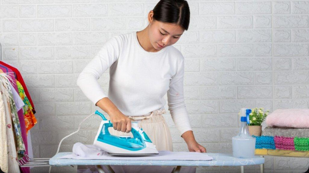 Ilustrasi menyetrika pakaian.