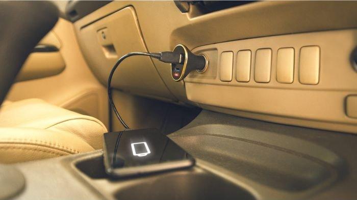 Ilustrasi mengecas HP di mobil dalam perjalanan.