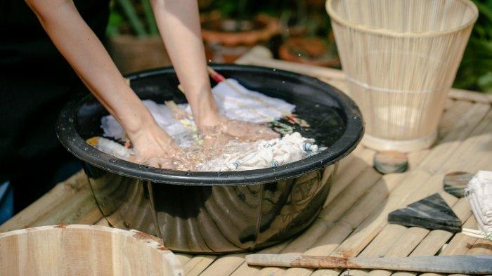 Ilustrasi merendam pakaian dair batik cap untuk cara perawatan terbaik.