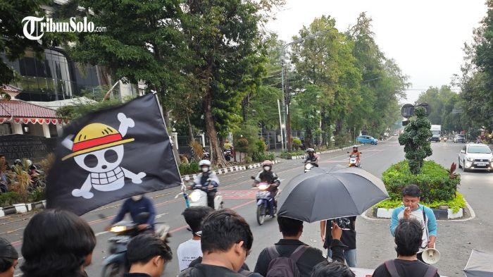 AKSI KAMISAN - Sejumlah orang menggelar Aksi Kamisan di Perempatan Gladag, Kamis (7/8/2025) dengan mengibarkan bendera One Piece. Bendera One Piece dianggap sebagai bentuk keresahan atas kondisi bangsa.