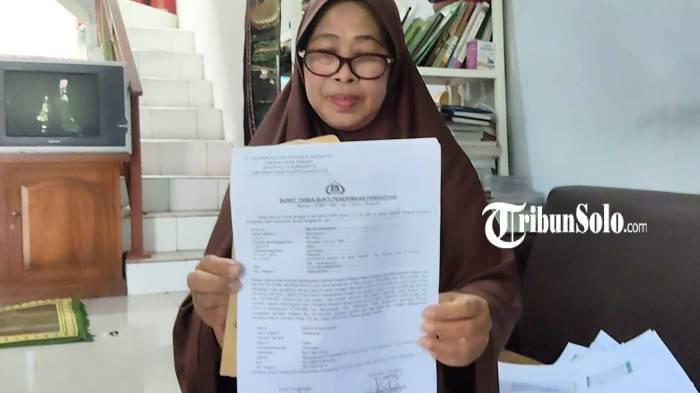BUKTI LAPORAN. Sri Wijiningsih (61), warga Perum Klodran Indah, Desa Klodran, Kecamatan Colomadu, Kabupaten Karanganyar saat ditemui, Selasa (2/6/2026). Dia menunjukkan bukti laporan polisi.