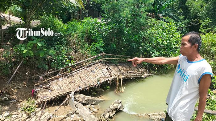 JEMBATAN DARURAT RUSAK - Salah seorang warga Dukuh Pringjowo, Desa Krobokan, Kecamatan Juwangi, Boyolali melihat puing jembatan darurat yang hanyut, Rabu (22/10/2025). Terputusnya jembatan darurat itu membuat pemerintah desa setempat prihatin. Pasalnya, jembatan itu menjadi satu-satunya penghubung setelah jembatan utama roboh pada 2019.