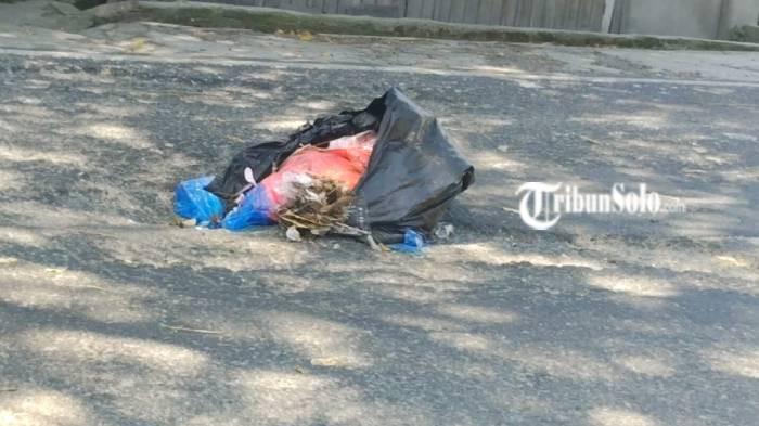 Jalan berlubang ditutup sampah