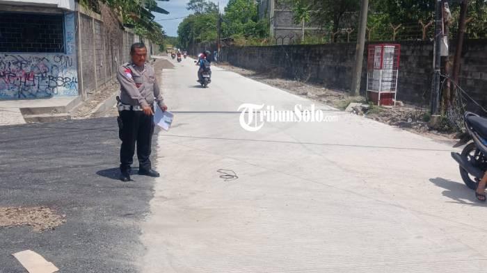 EVAKUASI. Anggota Satlantas Polres Karanganyar melakukan olah tkp di Jalan Widoro kandang tepatnya simpang empat Gudang pakan ternak, Desa Ngringoz Kecamatan Jaten, Kabupaten Karanganyar, Jum'at (28/11/2025). Seorang pengendara motor tewas akibat kejadian ini.