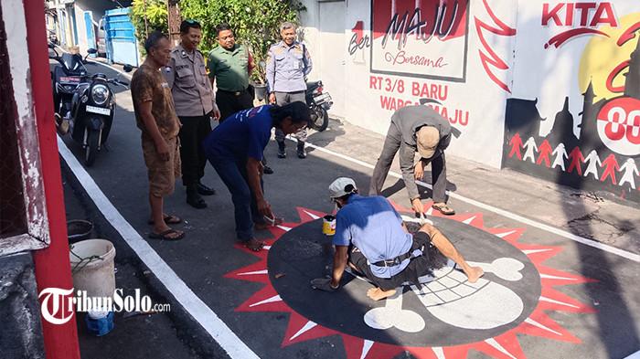 MURAL DIHAPUS - Sebuah mural logo kartun anime one piece di RT 3 RW 8 Kelurahan Sewu, Jebres dihapus atas arahan lurah dan personel TNI Polri, Senin (4/8/2025). Camat Jebres Samsu Tri Wahyudi mengungkapkan penghapusan ini dilakukan dengan alasan menjaga kondusifitas.