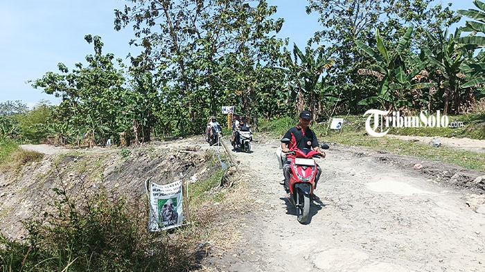 Pengendara motor saat melintasi jalan rusak yang menjadi akses utama warga Desa Krobokan, Boyolali