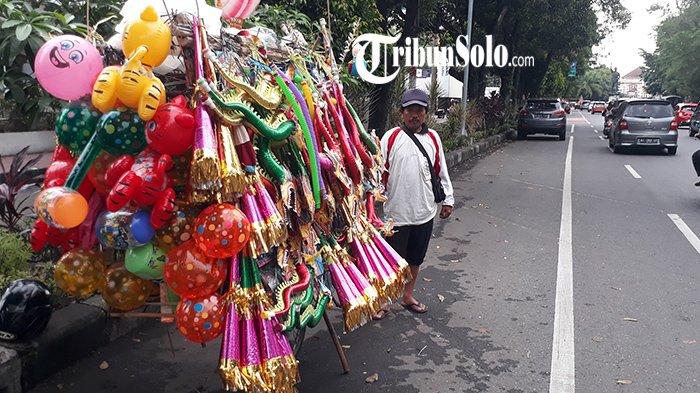 Penjual terompet asal Kecamatan Bulukerto, Wonogiri bernama Giatmo di area Gladak, Jalan Slamet Riyadi, Kota Solo, Sabtu (31/12/2022).