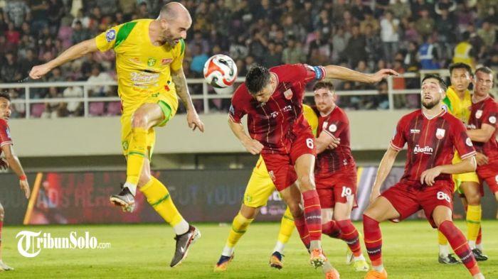 BEREBUT BOLA - Pesepak bola Persebaya, Milos Raickovic berduel udara dengan pesepak bola Persis Solo, Luka Dumancic dalam pertandingan Super League di Stadion Manahan, Solo, Sabtu (9/5/2026) malam. TRIBUNNEWS/Muhammad Nursina