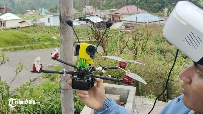 TERBANGKAN DRONE - Pungki Sasando memperlihatkan pesawat drone untuk memantau sekitar Bukit Mongkrang, Kamis (29/1/2026). Drone berhasil menangkap gambar dari pos pendakian pertama hingga warung di lereng, namun puncak bukit tidak terjangkau karena sinyal hilang di balik bukit.