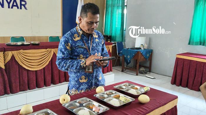 SAFE EAT MBG - Guru Ekonomi di SMAN 2 Karanganyar, Taupik Mulyadi menunjukan simulasi aplikasi Safe Eat MBG yang dibuatnya untuk mencegah terjadi keracunan pada siswanya apabila menyantap MBG, Jum'at (17/10/2025). Aplikasi itu bekerja menggunakan Artificial Intelligence (AI) atau kecerdasan buatan untuk menguji kelayakan menu MBG yang akan disantap pelajar SMAN 2 Karanganyar.