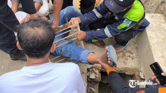 Seorang pedagang asongan terjebak dalam besi teralis penutup selokan