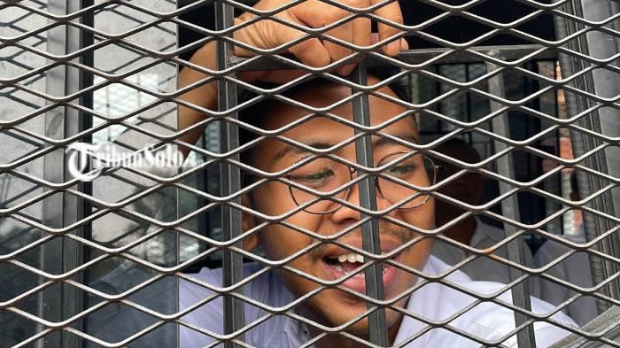 SENYUM. Surya Hendra Kusuma, penjaga palang pintu perlintasan kereta api di Sukoharjo saat berjalan keluar dari Pengadilan Negeri Sukoharjo, Kamis (22/1/2026). Surya divonis bebas oleh majelis hakim PN Sukoharjo.