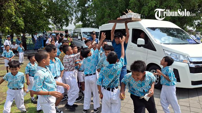 Tofa, pedagang sate ayam keliling saat membagikan dagangannya usai diborong keluarga keraton saat iring-iringan jenaza Raja Keraton Solo Sinuhun Pakubuwono XIII menuju Loji Gandrung, Rabu (5/11/2025). Alih-alih disantap sendiri, sate tersebut ternyata diminta pihak keraton untuk dibagikan ke anak-anak sekolah yang memberikan penghormatan terakhir untuk PB XIII.