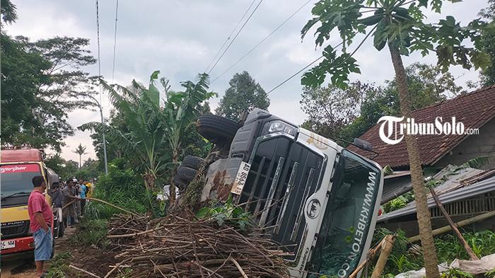 TERGULING KE RUMAH WARGA - Truk molen muatan cor beton terguling di Jalan Dali-Tamansari, tepatnya di Dukuh Dali, Desa Ringinlarik, Kecamatan Musuk, Kabupaten Boyolali, Rabu (12/11/2025). Truk bermuatan 7 kubik cor beton itu oleng dan terguling ke pekarangan rumah milik Suparmi, hingga bagian molennya menimpa kamar tidur.