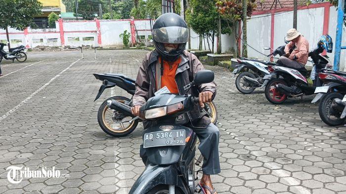 PAJAK NAIK - Tugiman mengendarai sepeda motor Suzuki Shogun usai membayar pajak kendaraan di Samsat Boyolali, Jumat (13/2/2026). Tugiman mengaku harus merogoh kocek hingga Rp 250 ribu untuk mengurus pajak sepeda motor Suzuki Shogun keluaran tahun 2001 miliknya.