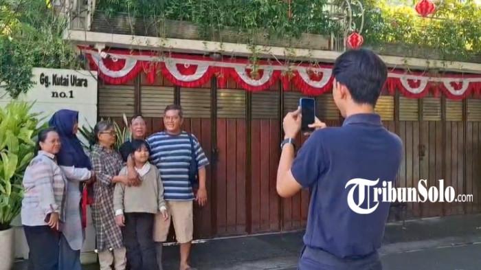 WISATAWAN DATANGI RUMAH JOKOWI - Warga Surabaya berfoto di depan kediaman rumah Jokowi di Sumber Solo, Minggu (17/8/2025). Sementara itu, Jokowi menghadiri upacara bendera di Istana Negara.