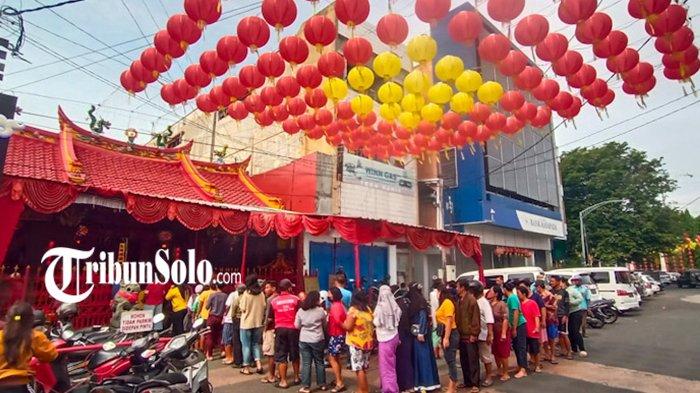Warga mengantre pembagian bantuan sembako beras di Kelenteng Tien Kok Sie Pasar Gede Solo, Minggu (5/2/2023).