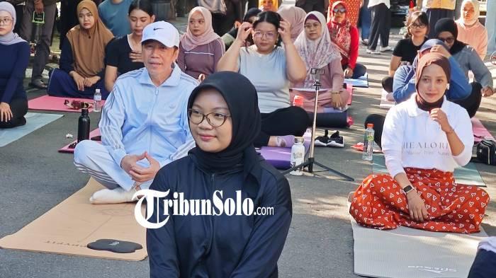 BUGAR. Sejumlah warga mengadakan sesi yoga di depan kediaman Jokowi di Gang Kutai Utara 01, Sumber, Banjarsari, Solo, Minggu (17/5/2026). Jokowi pun sempat mengikuti beberapa saat sebelum kembali melanjutkan aktivitas.