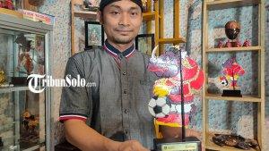 Pemilik-Sanggar-Wayang-Gogon-Margono-memegang-sampel-suvenir-Piala-Dunia-U-20.jpg