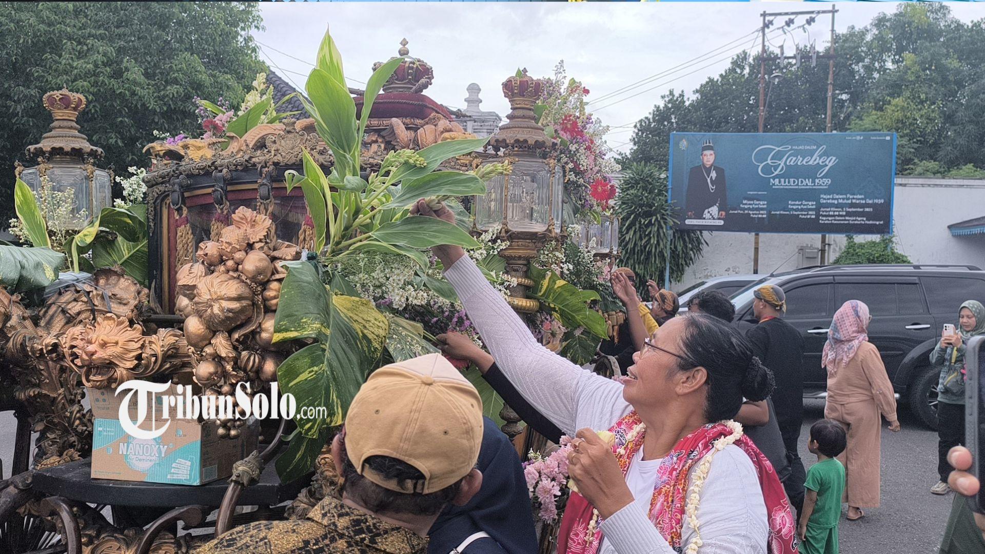 BEREBUT-HIASAN-Warga-tampak-berebut-bunga-hiasan-dari-Kereta-Kyahi-Garuda-Kencana.jpg