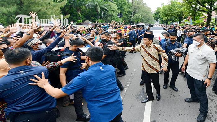 Presiden-Joko-Widodo-Jokowi-saat-bagi-bagi-kaus-untuk-warga.jpg