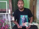 Harry-Setiawan-Jelipele-saat-memegang-foto-semasa-hidup-Marthen-Jelipele-di-rumah-duka.jpg
