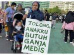 Seorang-ibu-melakukan-aksi-membawa-poster-yang-bertuliskan-membutuhkan-ganja-medis.jpg