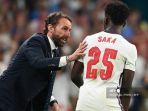 pelatih-inggris-gareth-southgate-kiri-berbicara-dengan-gelandang-inggris-bukayo-saka.jpg