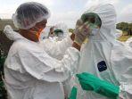 petugas-mengenakan-masker-dan-hazmat-suit.jpg