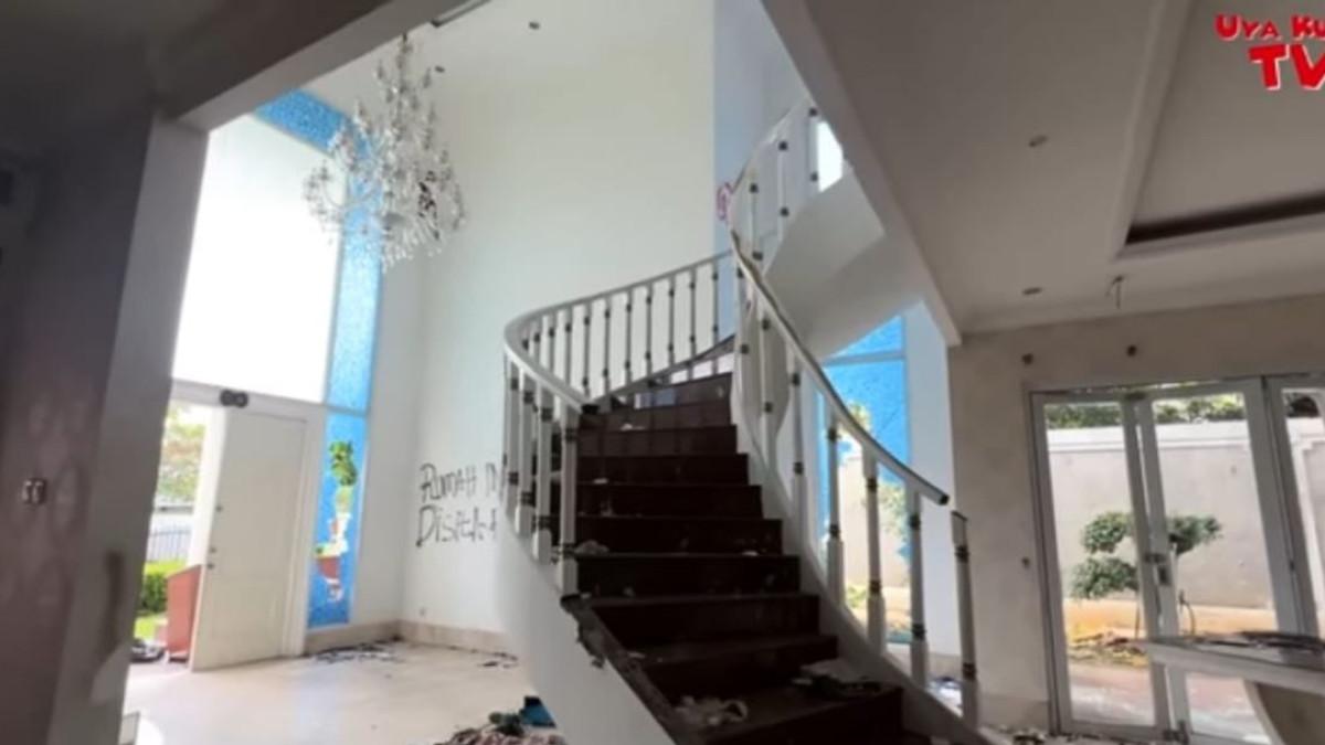 RUMAH UYA KUYA - Berbeda dengan ruang tamu yang hanya dipenuhi sampah, di ruang tengah masih ada sisa satu bupet berwarna putih yang diletakkan dekat kaca.