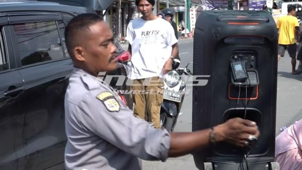 Pinkan Mambo terlihat menggunakan speaker sederhana dan menyiapkan kardus sebagai wadah saweran dari para pengguna jalan.