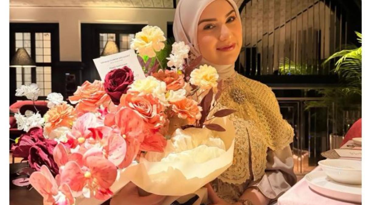 PERAYAAN ANNIVERSARY - Salah satu potret memperlihatkan Irish Bella memegang buket bunga besar bernuansa pink, peach, dan putih.